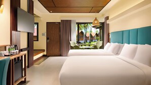 A hotel room with a bed, a desk with a refrigerator, a dining area with chairs, and a view of the outside. - Hilton Garden Inn Kota Kinabalu Tuaran (Tuaran)