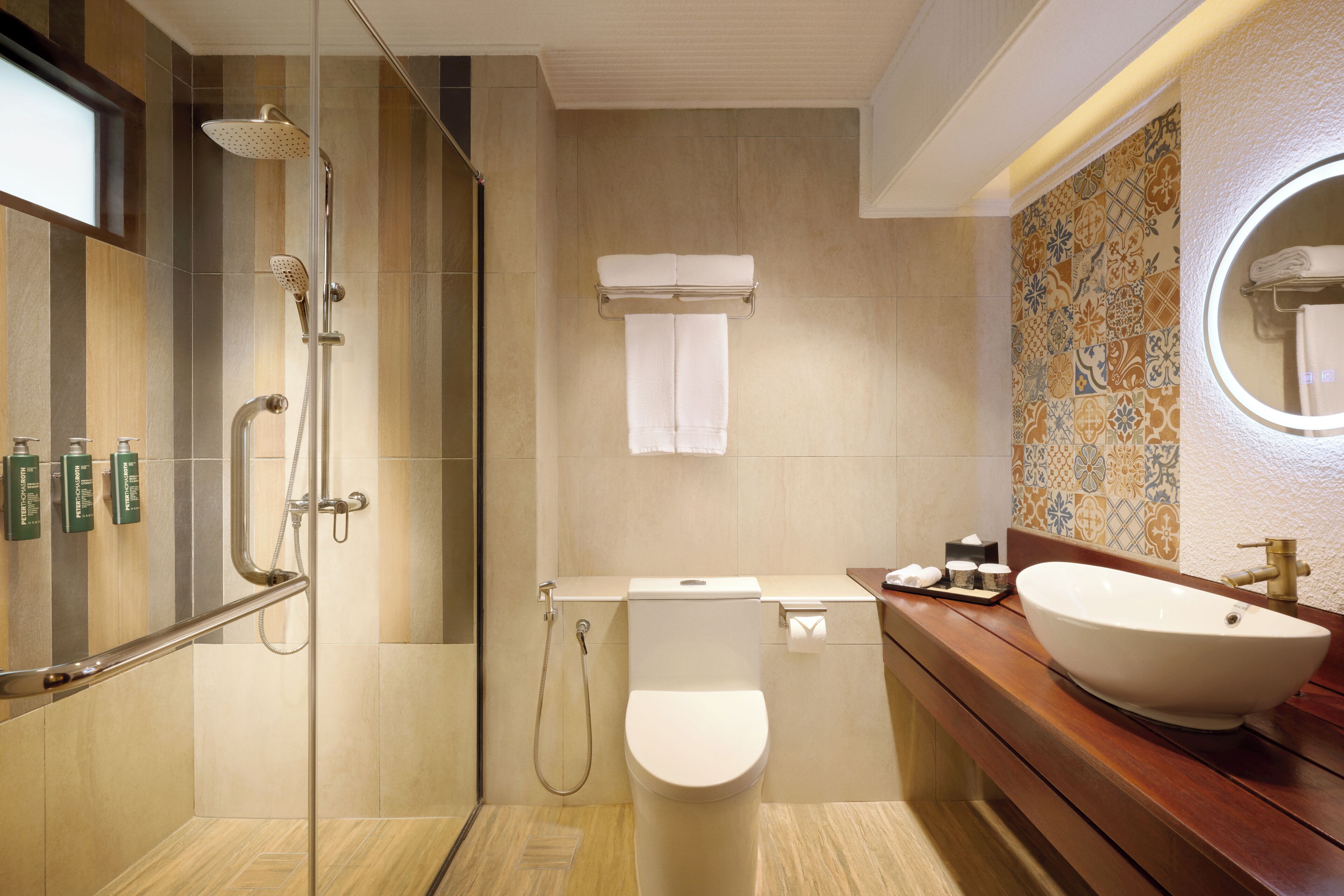 A modern bathroom with a glass-enclosed shower, a toilet, a sink with a large basin, and a mirror.