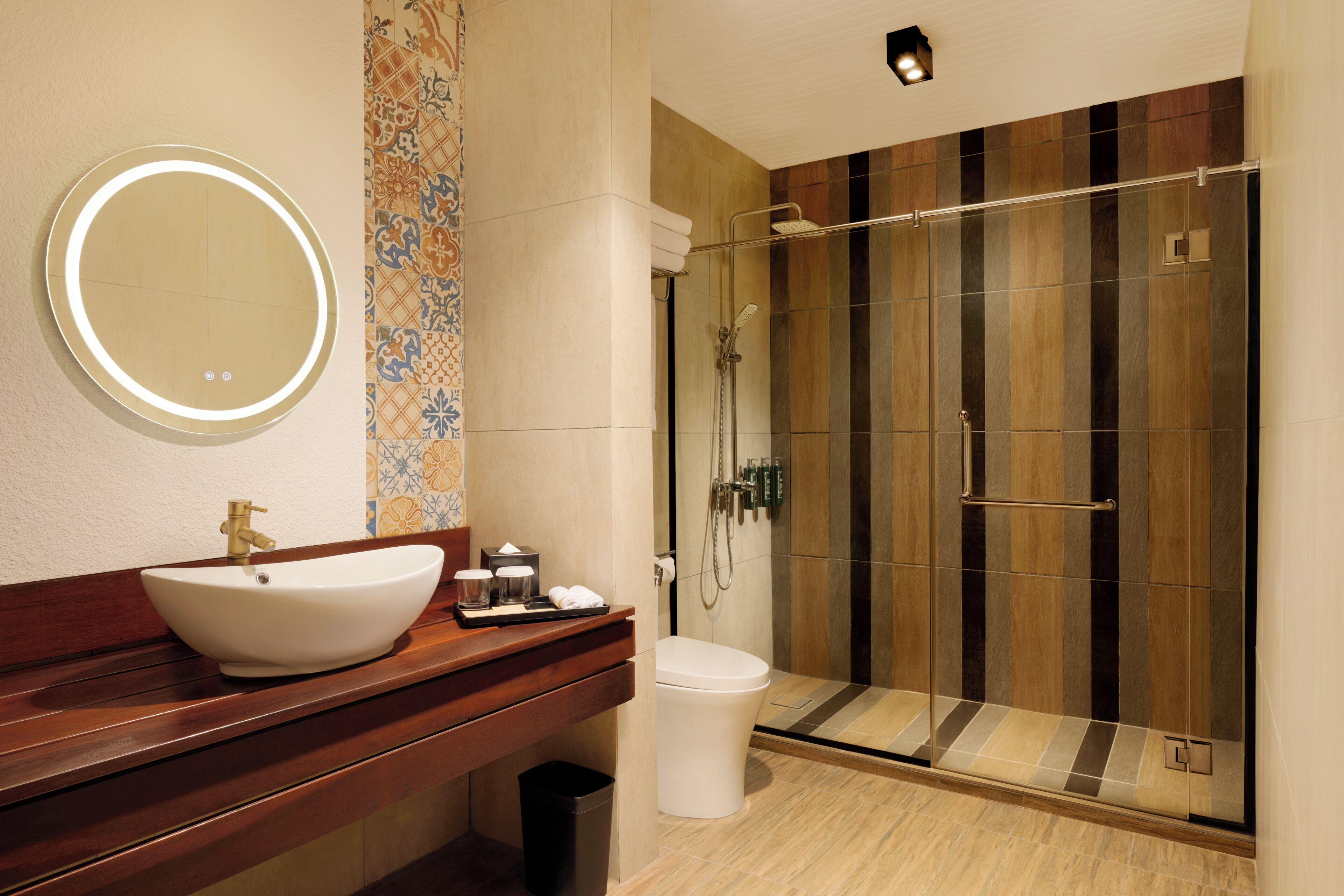 Un baño con un lavamanos grande, un inodoro, una ducha con puerta de cristal y un espejo.
