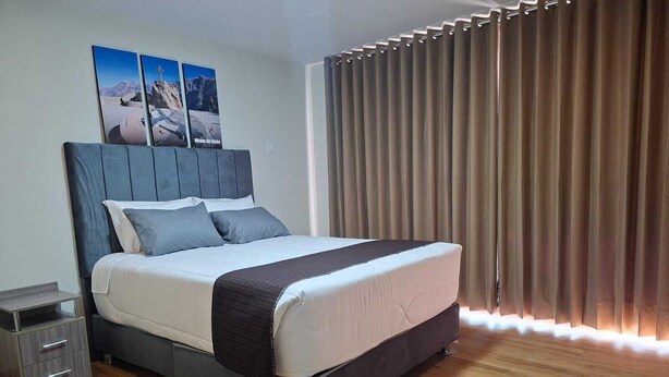 A modern bedroom with a large bed, a nightstand, and a wardrobe. - Hotel Rosa Mistica Inn (Arequipa)
