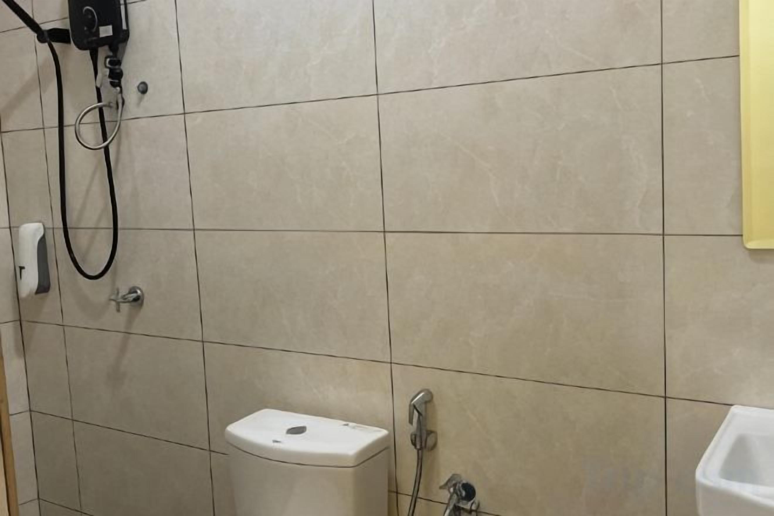A bathroom with a toilet, a shower, and a sink.
