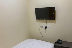 A room with a bed, a television mounted on the wall, and a telephone on a table. - Sunshine Hotel (Bahau)