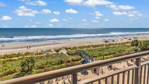 A beach with a clear view of the ocean and a promenade with steps leading down to the beach. - Bluewater Resort 406 (Myrtle Beach)