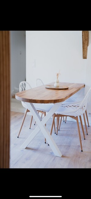 A dining table with a wooden top and white chairs. - CINEMA Lune (Montfrin)