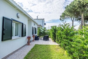 Ein modernes Haus mit gepflasterter Terrasse, Gartenmöbeln und einem gepflegten Garten.