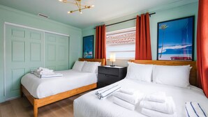 Une chambre double avec deux lits, une table de chevet, une lampe, un tableau et une fenêtre avec des rideaux.