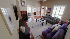 A living room with a sofa, coffee table, and a flat-screen TV. - Courtyard Haven Stylish 3BR Retreat (Prairieville)