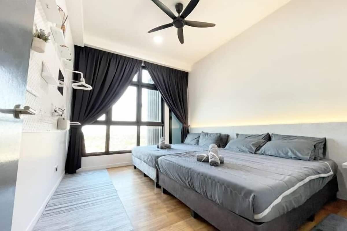A modern bedroom with two beds, a ceiling fan, and a large window with curtains.