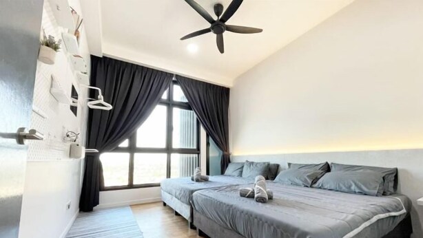 A modern bedroom with two beds, a ceiling fan, and a large window with curtains.