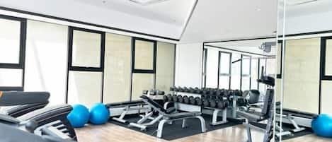 A gym with exercise equipment, treadmills, and weights.