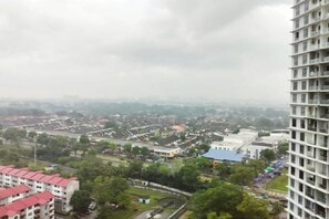 Un edificio alto con vistas a un paisaje urbano, que incluye zonas residenciales y un campo deportivo.