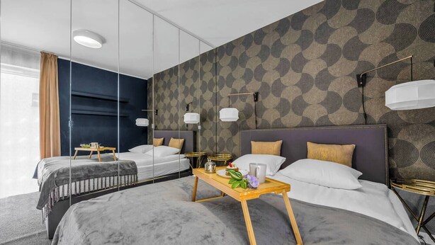 A modern hotel room with two beds, a large mirror, and a tray table with breakfast items. - Praga Apt - Parking, Terrace - by Rentujemy (Warszawa)