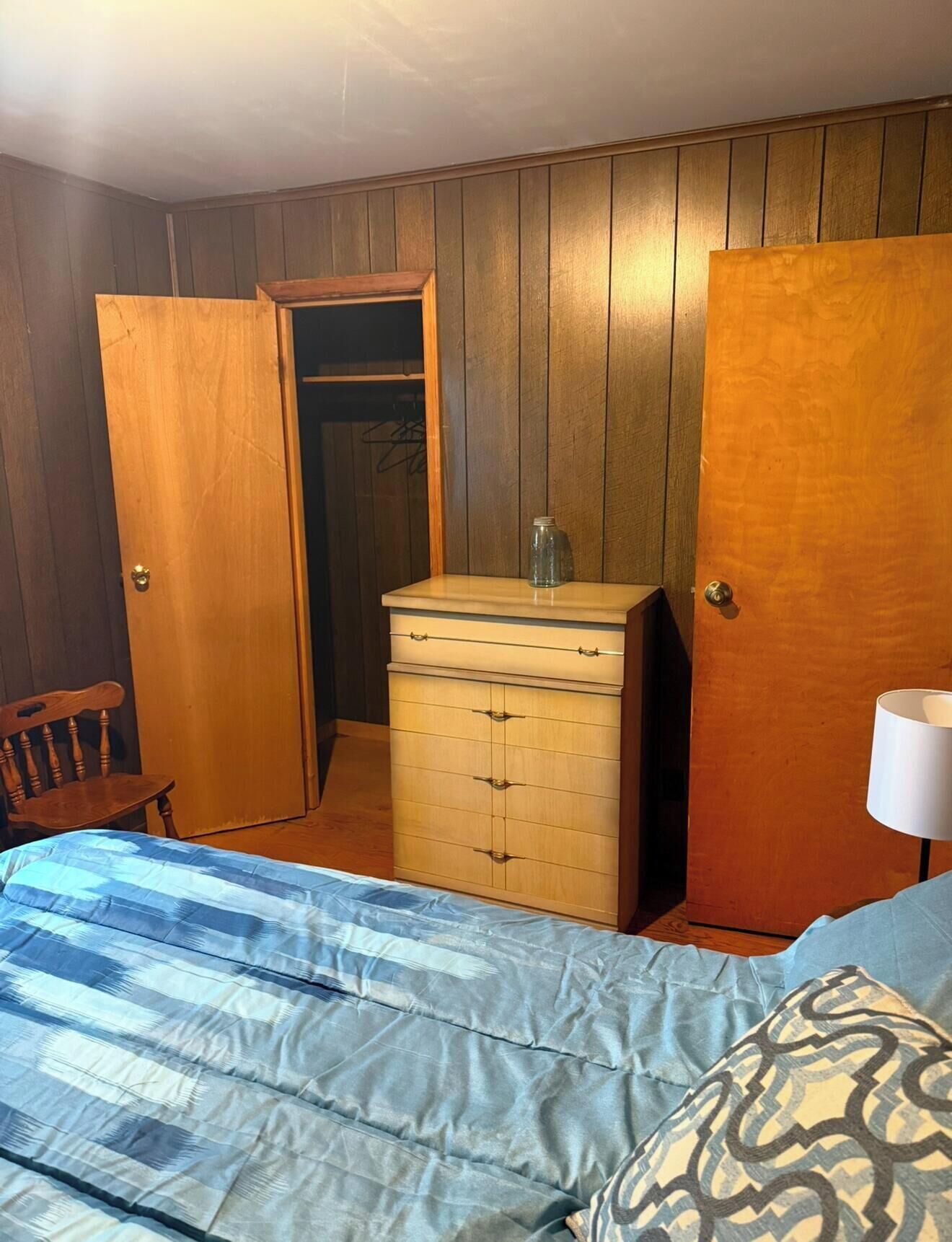 A bedroom with a bed, dresser, and wardrobe.