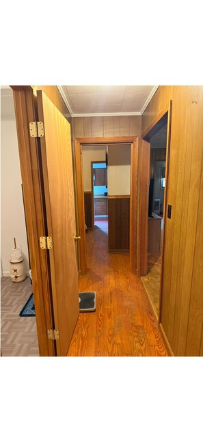 A wooden hallway with a sliding door leading to a kitchen area. - Charming 3-bedroom house in welcoming Dugspur with peace of mind. (Dugspur)