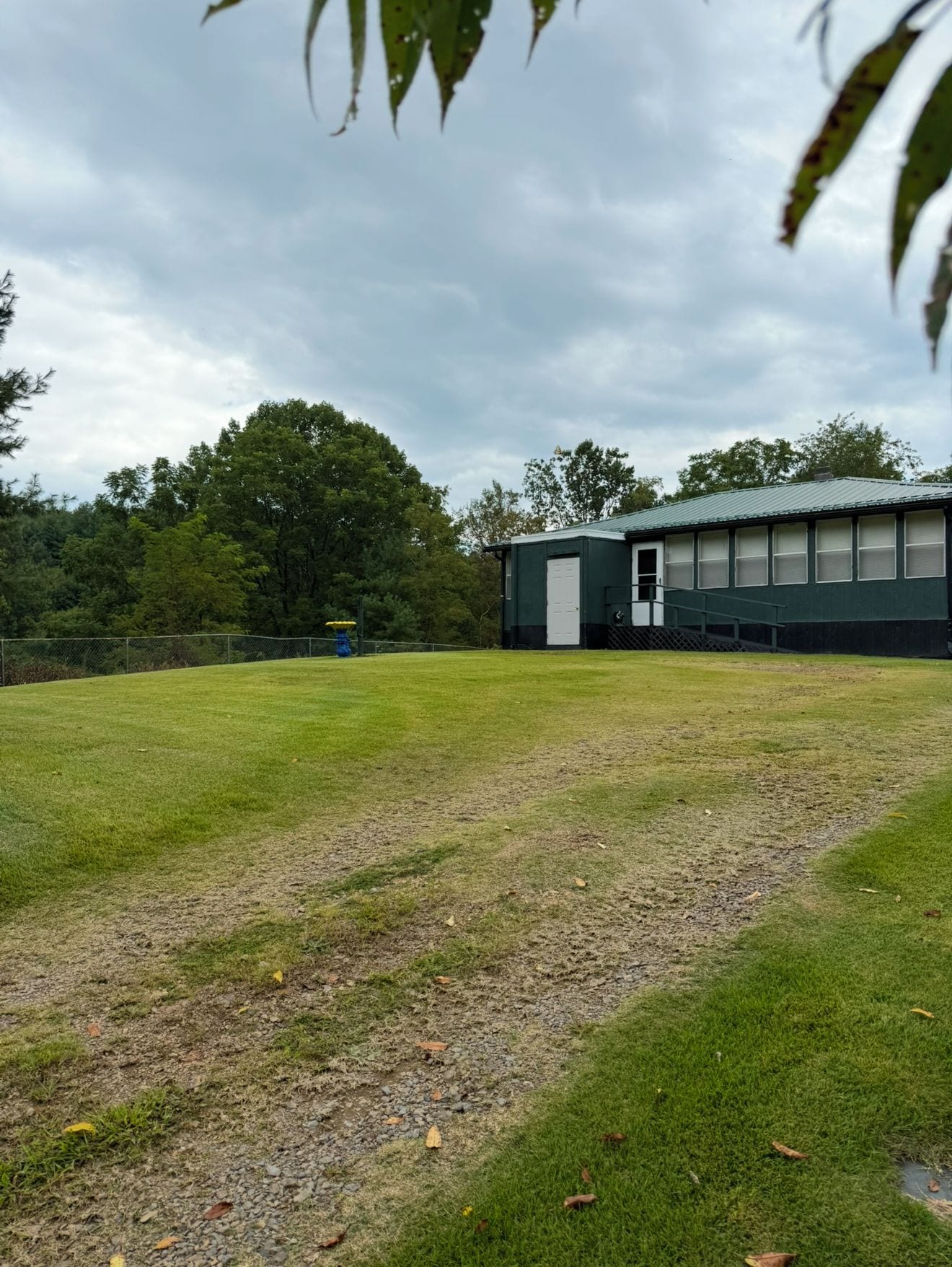 A grassy field with a building in the background.