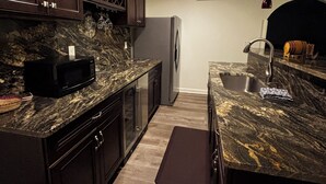 A modern kitchen with dark wood cabinets, granite countertops, and stainless steel appliances.