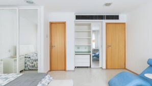 Un dormitorio con cama, escritorio y armario.