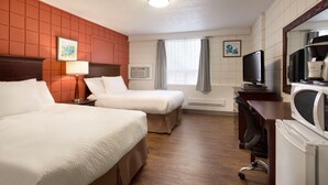 Une chambre d’hôtel avec deux lits, un bureau, une télévision et un four à micro-ondes.