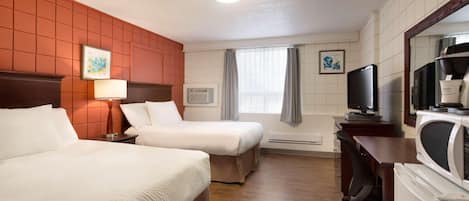A hotel room with two beds, a desk, a television, and a microwave.