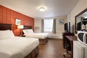 Habitación de hotel con dos camas, un escritorio, televisor y microondas.