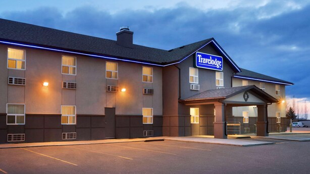 Un hôtel Travelodge au design moderne, doté d’une entrée bien éclairée et d’un parking.
