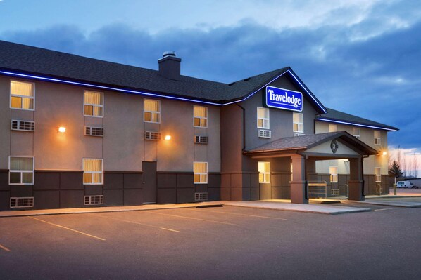 Un hotel Travelodge con diseño moderno, que cuenta con una entrada bien iluminada y un estacionamiento.
