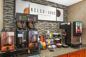 A coffee station with branded coffee machines, a water dispenser, and various coffee products. - Drury Inn Pikes Peak Colorado Springs (Colorado Springs)
