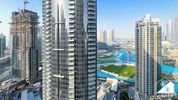 A high-rise building with a modern architectural design, featuring multiple balconies and a glass facade. - Skyline Elegance Fountain View 3BR in Downtown (Dubai)