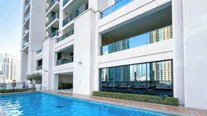 A modern building with a swimming pool, balconies, and large windows. - Skyline Elegance Fountain View 3BR in Downtown (Dubai)