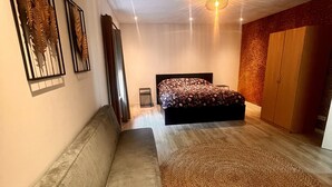 Un dormitorio moderno con una cama grande, un sofá y una alfombra estampada.