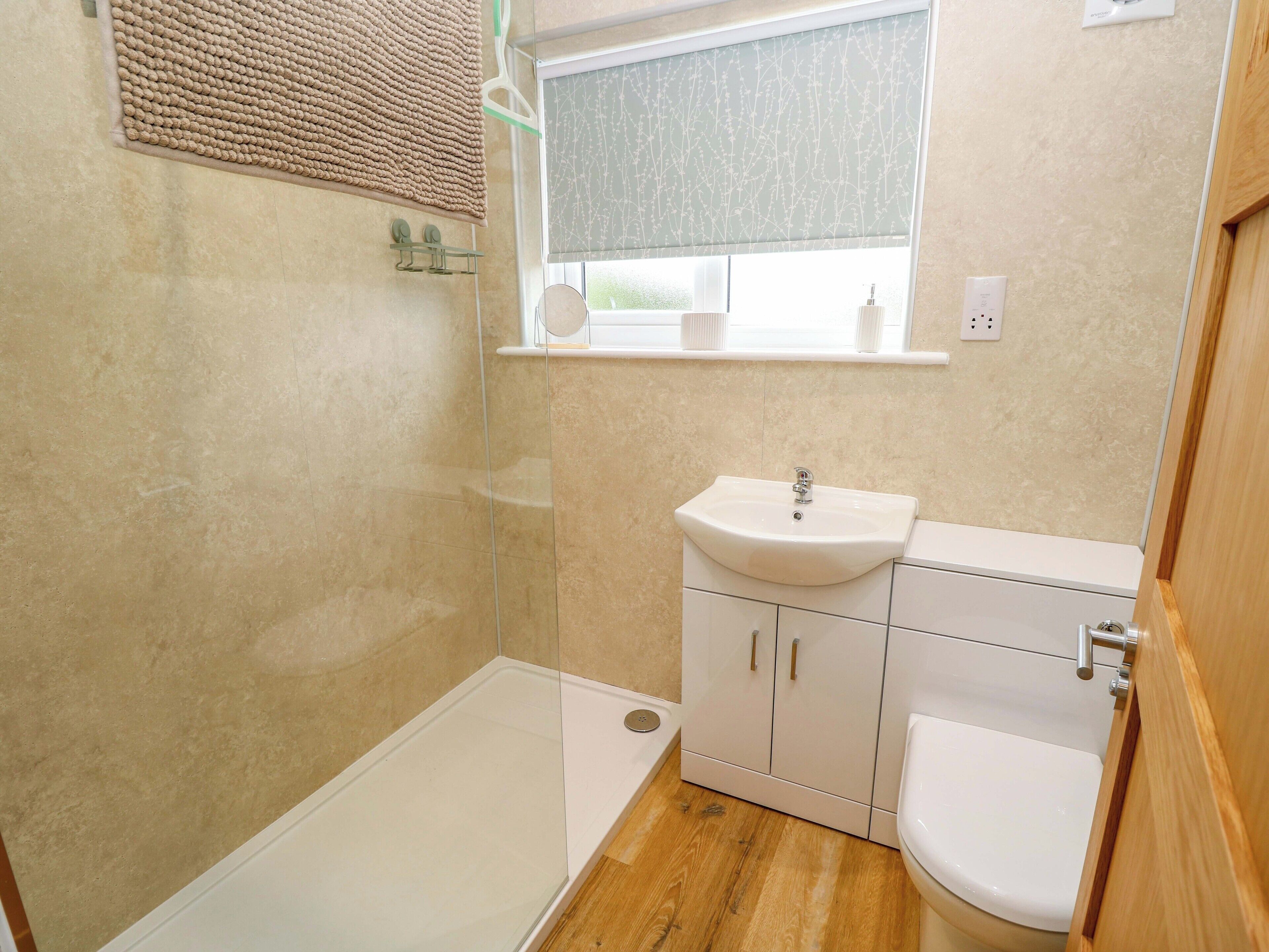 A bathroom with a shower, sink, and toilet.
