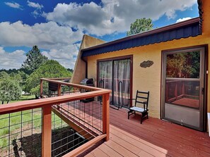 A wooden deck with a metal railing, a grill, and a chair. - Alto Mountain Sojourn by Ruidoso Vacation Rentals (Alto)
