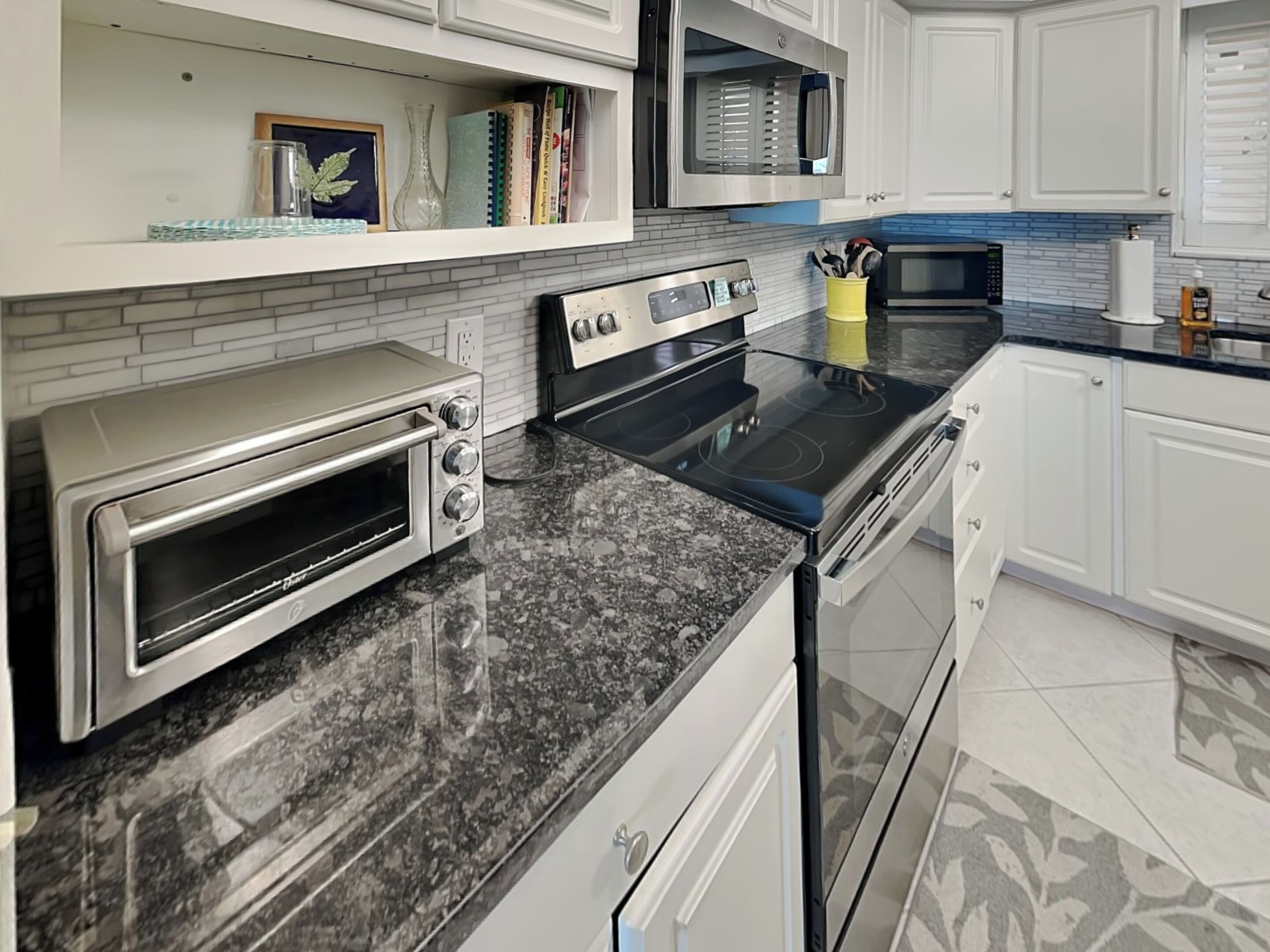 Een moderne keuken met een ingebouwde oven, magnetron en kookplaat.