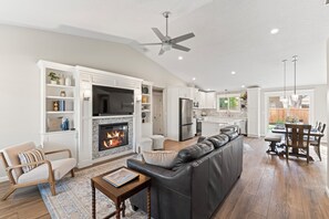 TV connectée, cheminée, livres, chaîne hi-fi