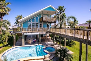 A two-story house with a balcony, a swimming pool, and a deck. - Margaritaville on the Bay by Ryson Vacation Rentals (Galveston)