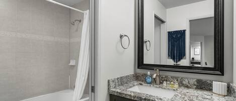 A bathroom with a shower, toilet, and sink.
