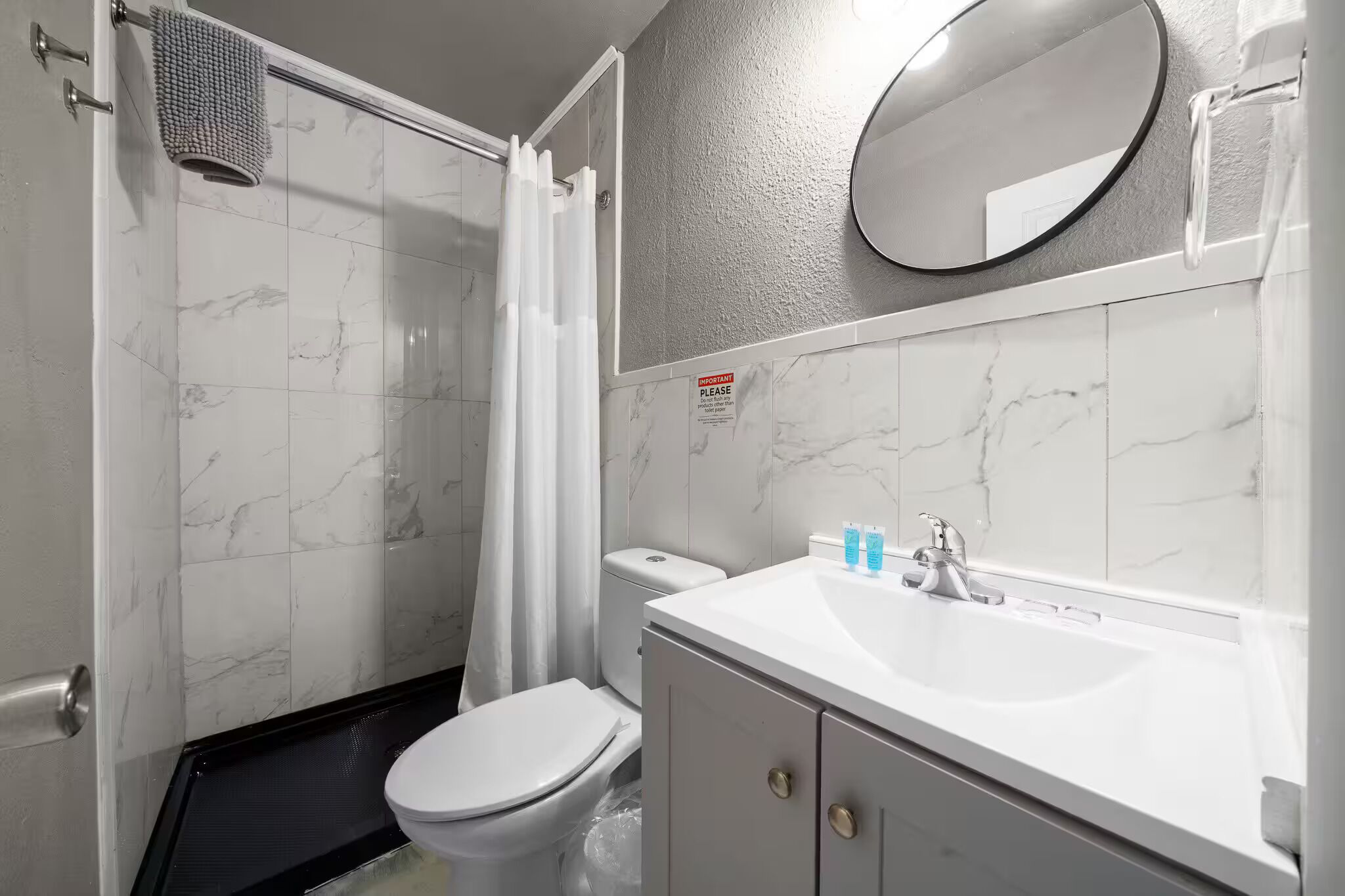 Une salle de bain avec des toilettes, une douche et un lavabo.