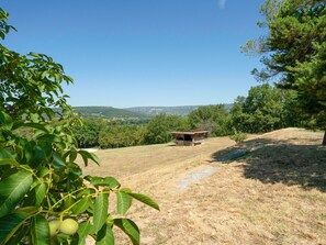 Eine rustikale Holzhütte in einer hügeligen Landschaft unter blauem Himmel.