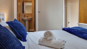 Una habitación de hotel con una cama, un lavamanos blanco y un mueble de madera.