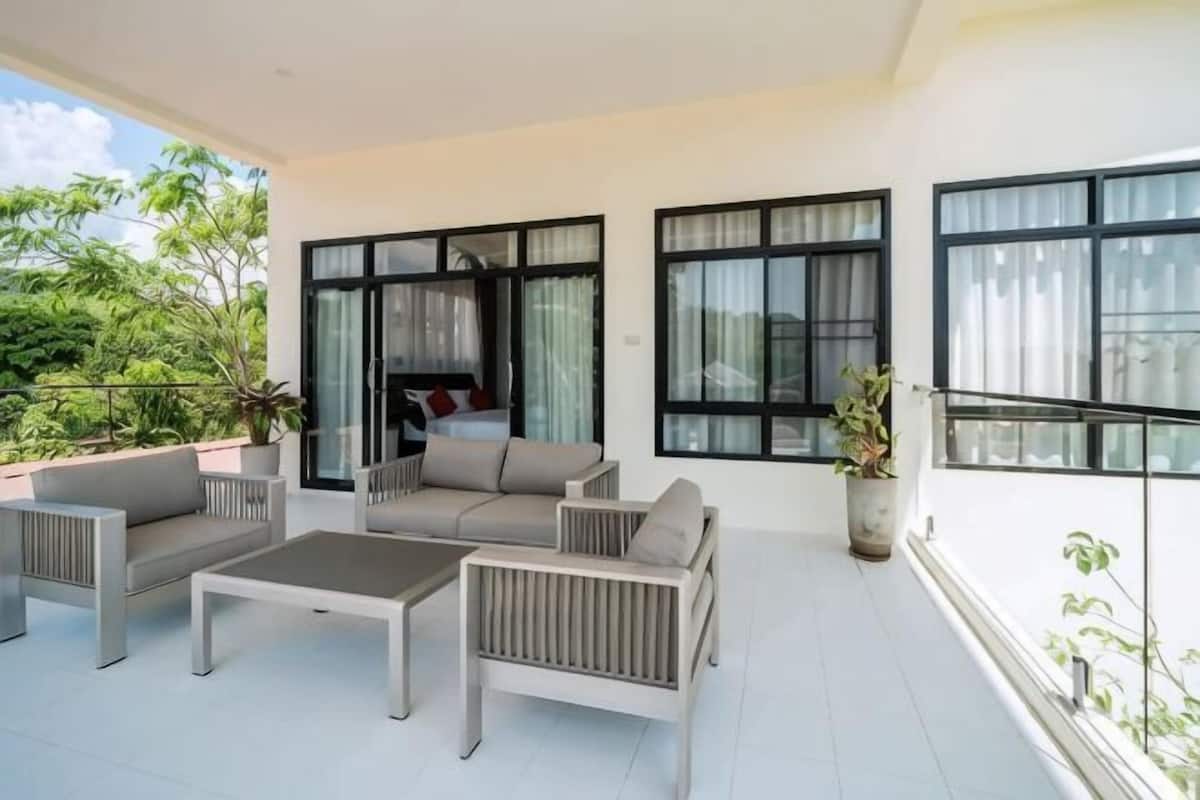 An outdoor living area with a sofa set, a coffee table, and potted plants.