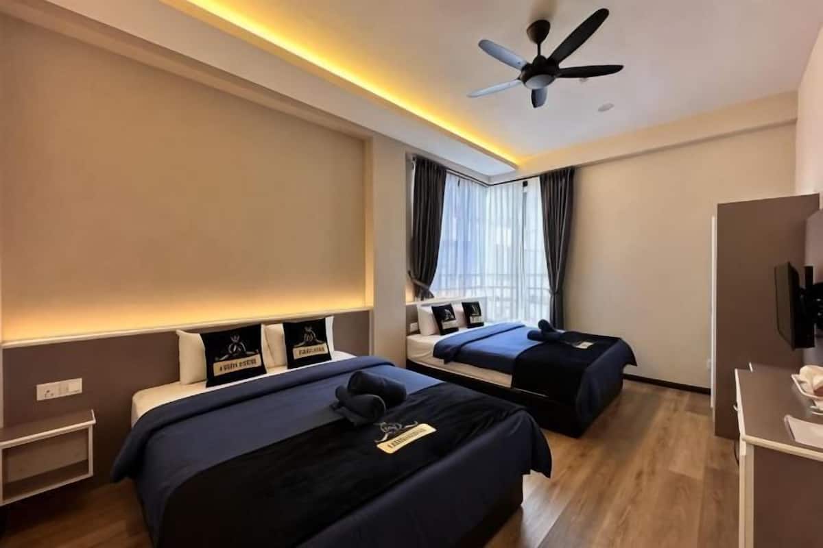 Een moderne hotelkamer met twee bedden, een plafondventilator en een groot raam met gordijnen.