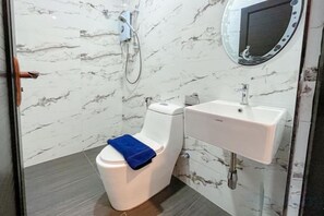 A bathroom with a toilet, a sink, and a mirror. - Hotel Lavie at Centrum (Brinchang)