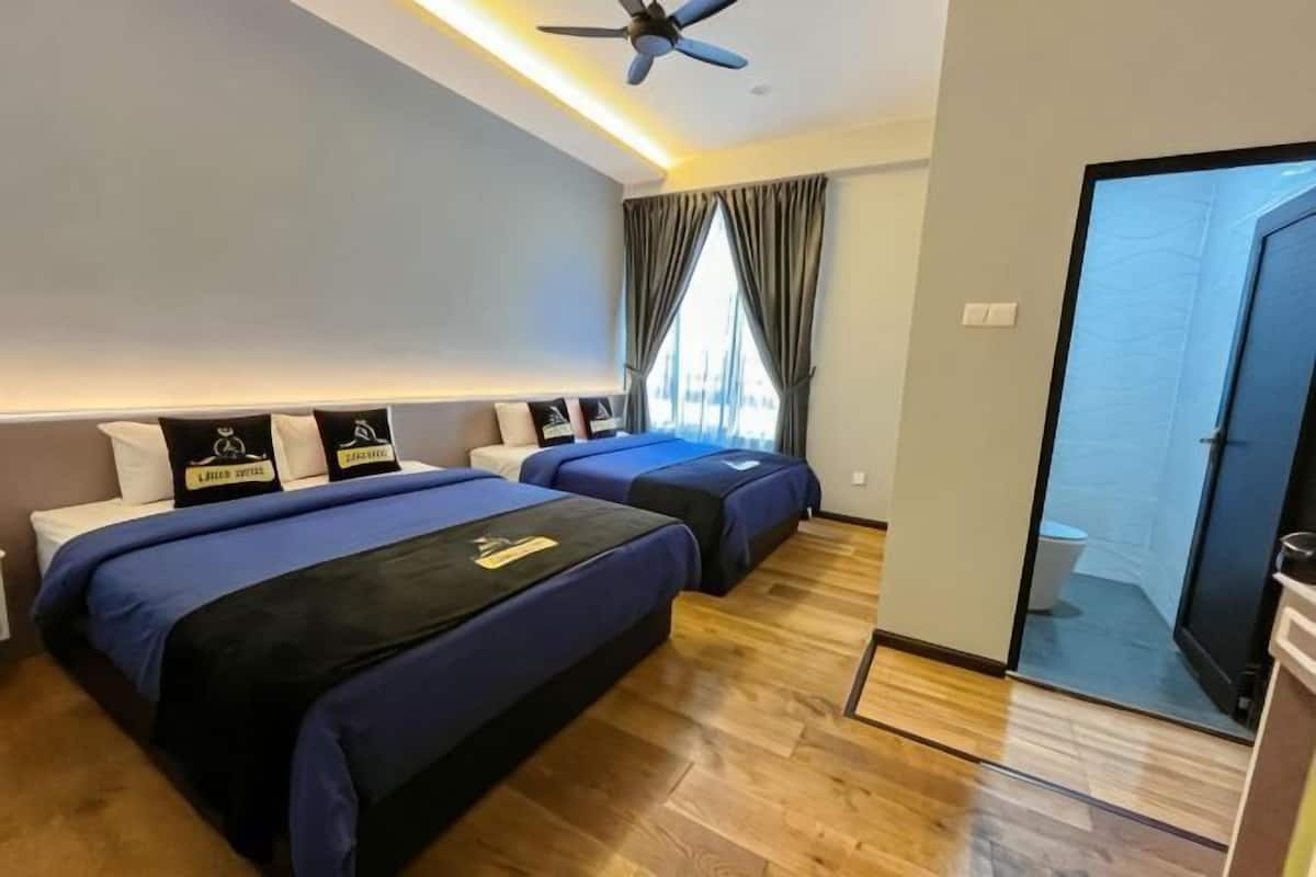 A hotel room with two beds, a ceiling fan, a sliding glass door to a balcony, and a visible bathroom.