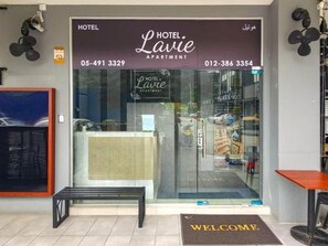 A hotel entrance with a reception desk, a welcome mat, and a glass door. - Hotel Lavie at Centrum (Brinchang)