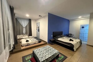 Ein Schlafzimmer mit zwei Betten, einem Schreibtisch, einem Stuhl und einem Fenster mit Vorhängen.