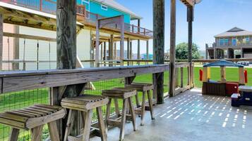 A covered outdoor area with wooden benches and a picnic table.
