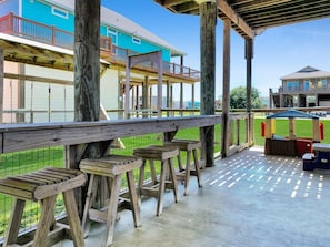 A covered outdoor area with wooden benches and a picnic table. - Ibis Isle-Bolivar Peninsula, Sleeps 12, Fenced Side Yard, Walk to Beach, In Town (Bolivar Peninsula)