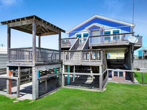A two-story building with a wooden deck and a covered area.