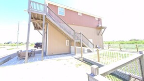 A two-story building with a wooden deck and a staircase.
