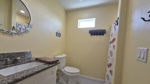 A bathroom with a sink, toilet, and shower curtain.